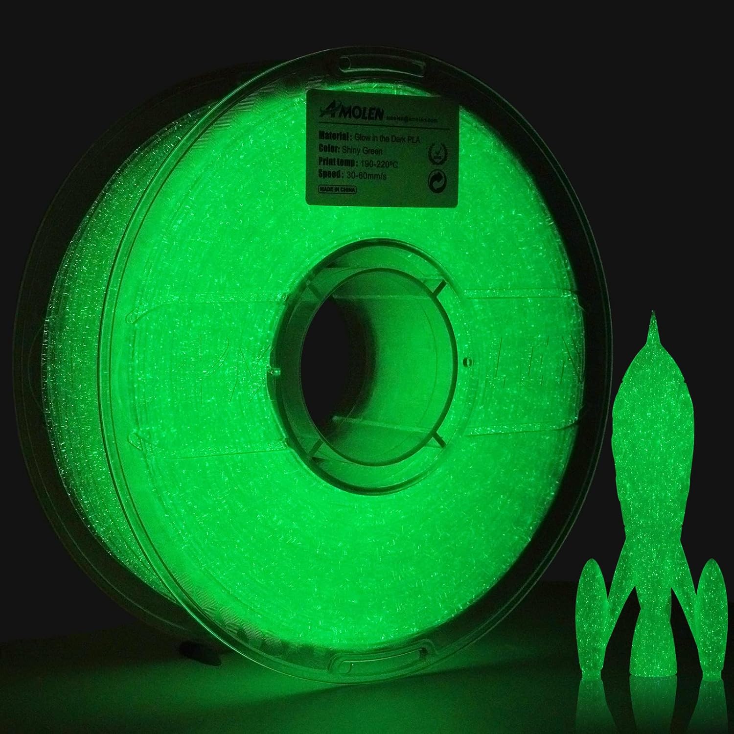 Amolen Glow-in-the-Dark PLA Shiny Green filament spool and 3D-printed rocket; perfect for glowing projects.